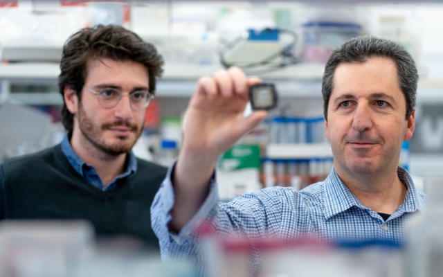 Le professeur Yaakov Nahmias (à droite) et le chercheur Aaron Cohen présentent la puce avec laquelle ils ont développé le médicament (photo : université hébraïque de Jérusalem)
